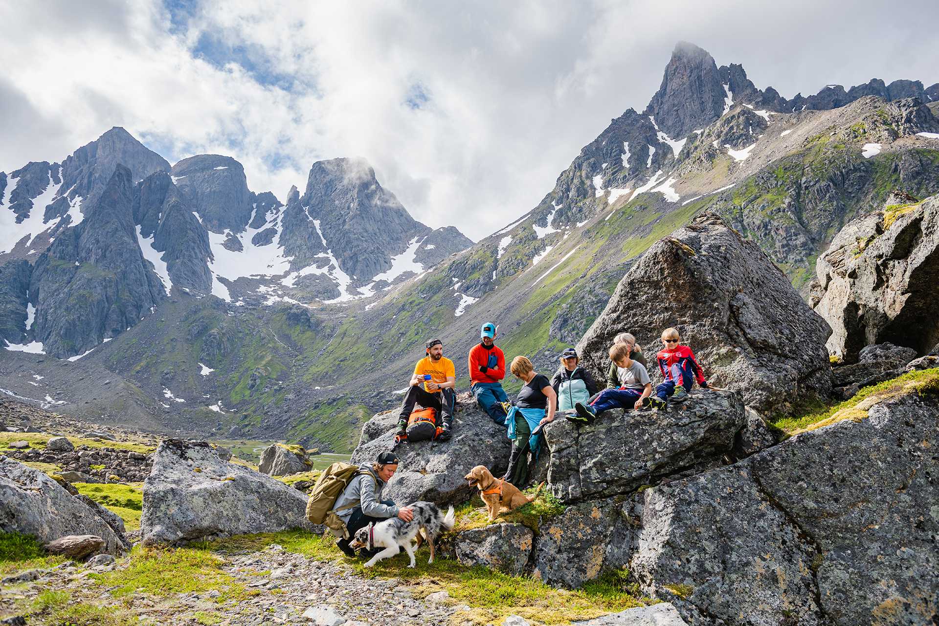 Familie raster på stein i fjellheimen. Foto.