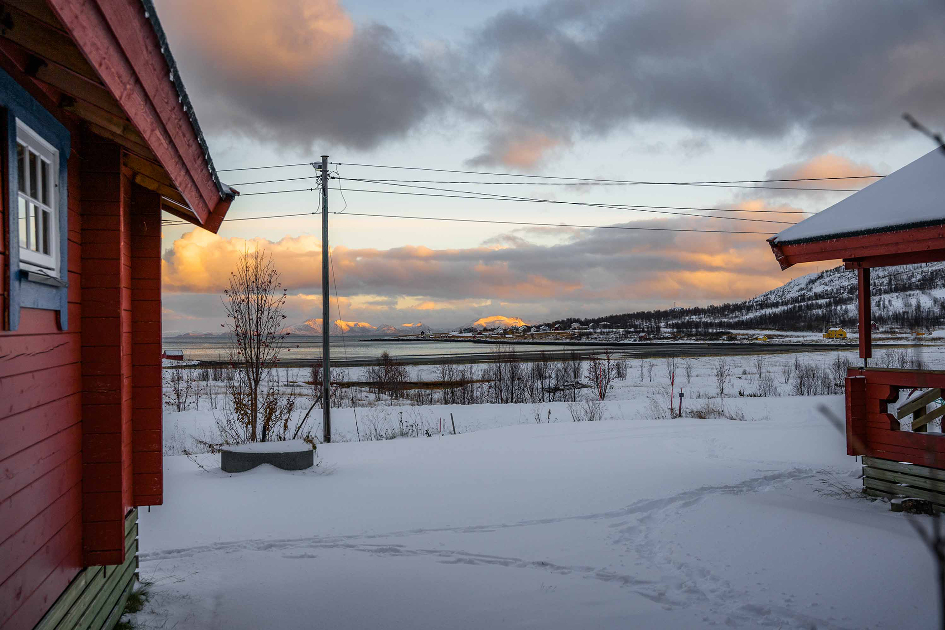 Utsikt mellom hytter ut mot hav. Foto.