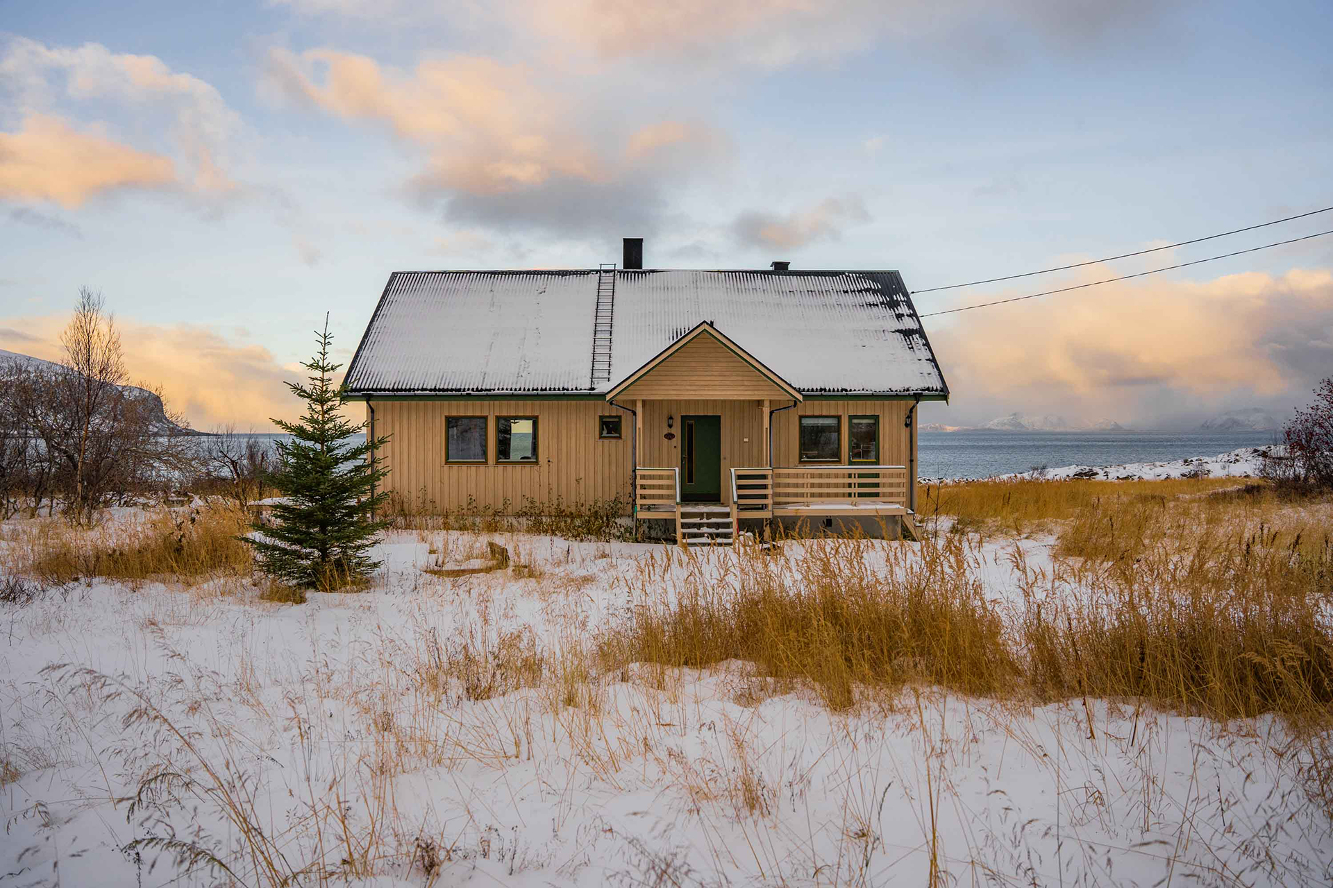 Trondhuset, gult hus ved sjøen sett utenfra. Foto.